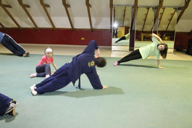 Eine Gruppe von Personen trainiert in einem Raum mit Spiegeln.