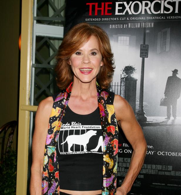 Linda Blair posiert vor einem Filmplakat von „Der Exorzist“.