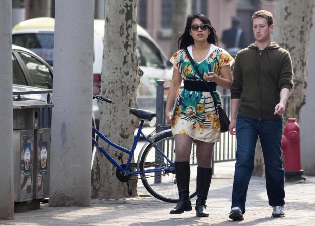 Mark Zuckerberg geht mit einer Frau die Straße entlang.