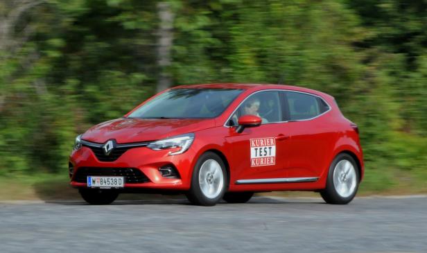 Ein roter Renault Clio fährt auf einer Landstraße.