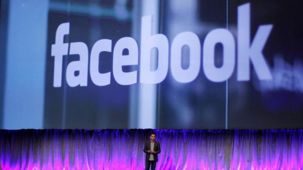Ein Mann steht vor einer Bühne mit dem Facebook-Logo.