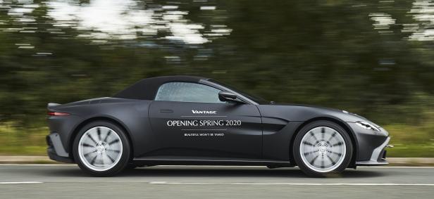 Ein schwarzer Aston Martin Vantage Roadster fährt auf einer Straße.