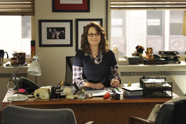 Tina Fey sitzt an ihrem Schreibtisch in ihrem Büro.