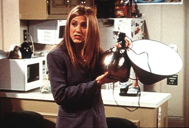Jennifer Aniston hält in einer Szene aus „Friends“ eine Lampe mit Lampenschirm.