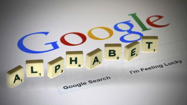 Der Schriftzug „Alphabet“ aus Scrabble-Steinen liegt vor dem Google-Logo.