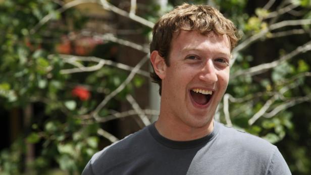 Mark Zuckerberg lacht vor einem Hintergrund aus Pflanzen.