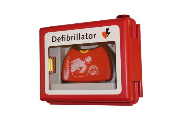 Ein Defibrillator in einem roten Wandkasten.