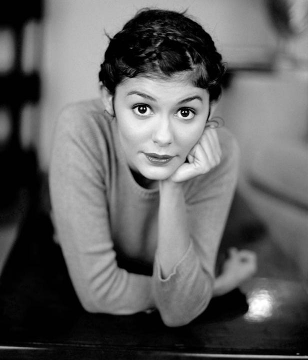 Schwarzweißporträt von Audrey Tautou, die auf ihren Armen liegt und in die Kamera blickt.