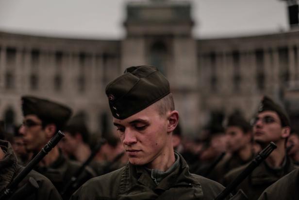 Soldaten in Uniformen stehen bei einer Militärparade stramm.