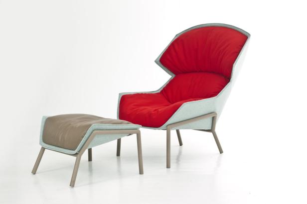 Ein moderner Sessel mit roter Polsterung und passendem Hocker auf einem weißen Hintergrund.