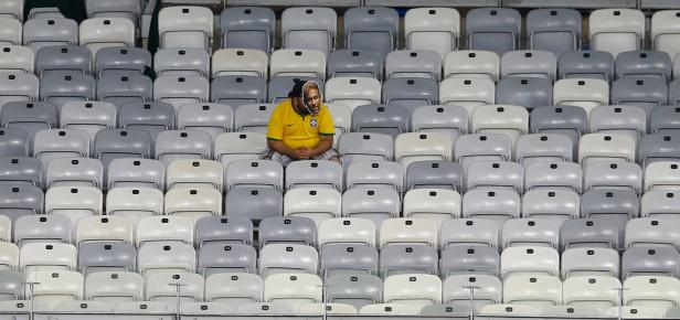 Ein Mann mit einem Neymar-Gesicht sitzt auf einem der leeren Sitze im Stadion.