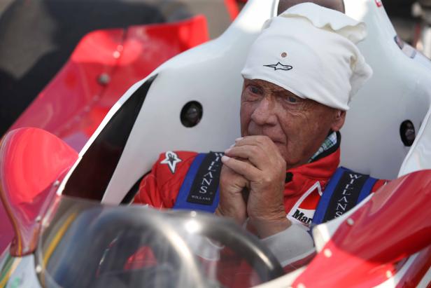 Niki Lauda sitzt in einem roten und weißen Rennwagen.
