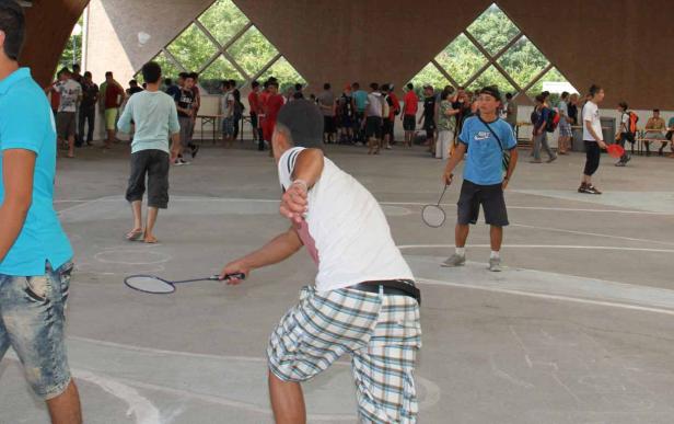In einer Halle spielen mehrere Personen Badminton.