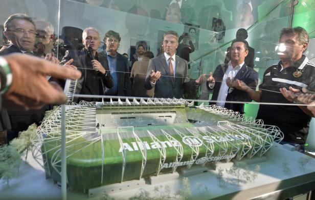 Mehrere Personen betrachten ein Modell des Allianz Stadions hinter Glas.