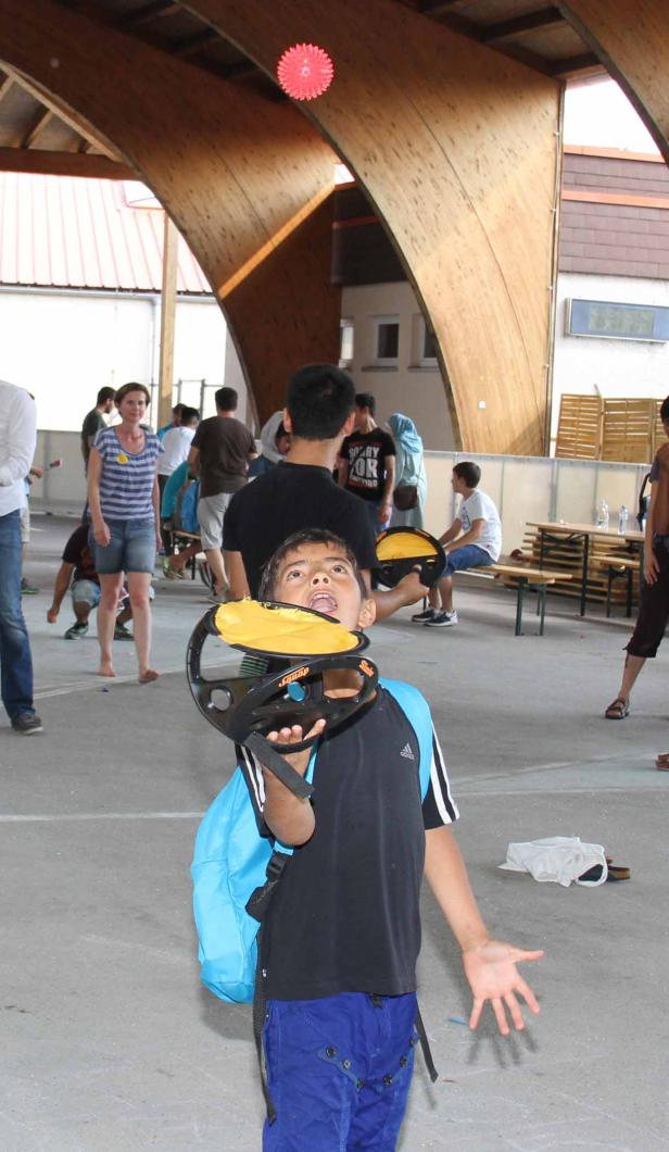 Ein Junge versucht, einen Ball mit einem Fangspielzeug zu fangen.