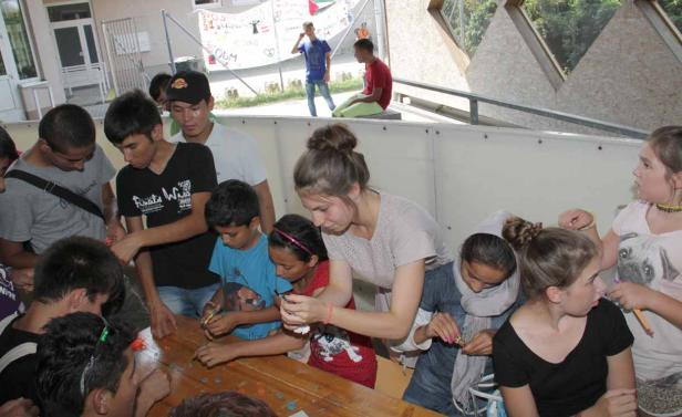 Eine Gruppe von Kindern bastelt gemeinsam an einem Tisch.