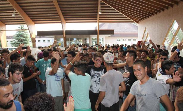 Eine große Gruppe junger Männer steht in einer Halle und jubelt.