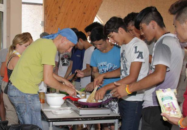 Eine Gruppe junger Leute kocht gemeinsam in einer Küche.