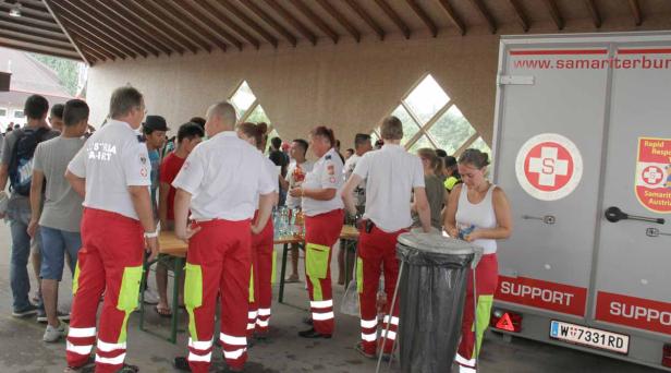 Sanitäter des Samariterbundes stehen vor einem Einsatzfahrzeug.