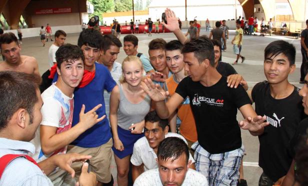 Eine Gruppe junger Leute posiert für ein Foto auf einem Sportplatz.