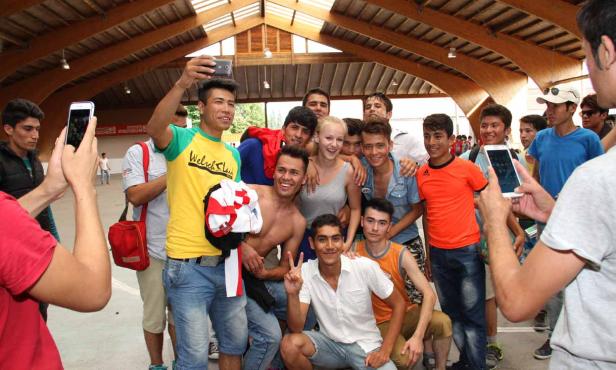 Eine Gruppe junger Leute posiert für ein Selfie in einer Halle.