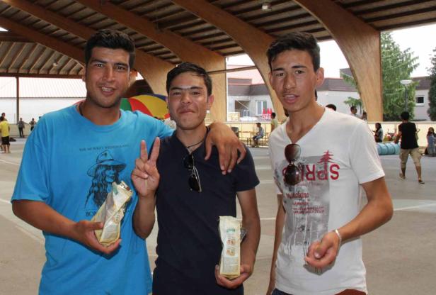 Drei junge Männer stehen zusammen und halten Päckchen in ihren Händen.