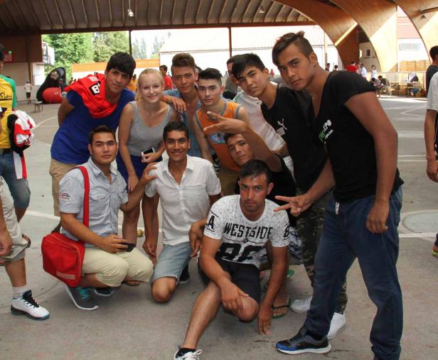 Eine Gruppe junger Leute posiert für ein Foto unter einem überdachten Bereich.