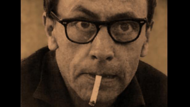 Ein Mann mit Brille und Zigarette im Mund, in Sepiatönen.