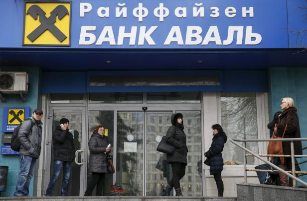 People stand next to a branch of the Raiffeisen Bank Aval in Kiev People stand next to a branch of the Raiffeisen Bank Aval in Kiev