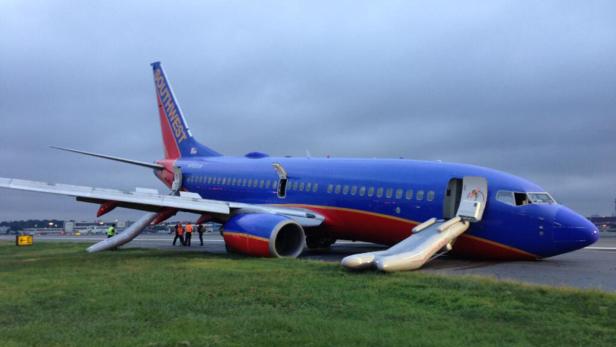 Ein Southwest-Flugzeug steht mit geöffneten Notrutschen auf einer Grasfläche.