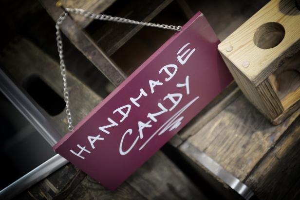 Ein Schild mit der Aufschrift „Handmade Candy“ hängt an einer Kette.