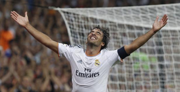 Ein jubelnder Fußballspieler von Real Madrid mit ausgestreckten Armen vor einem Tornetz.