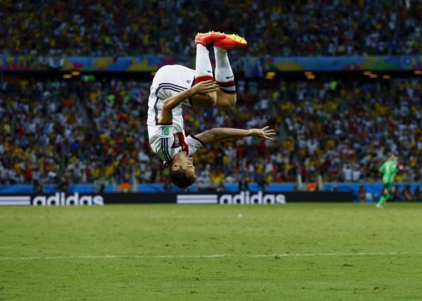 Ein deutscher Fußballspieler macht einen Salto auf dem Spielfeld.