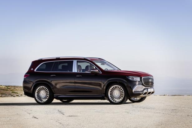 Ein rot-schwarzer Mercedes-Maybach GLS steht auf einer Anhöhe.