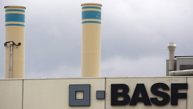 Zwei Schornsteine ragen über ein Gebäude mit dem BASF-Logo.