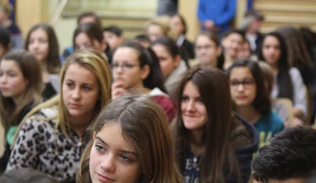 Eine Gruppe von Teenagern sitzt aufmerksam in einem Raum.