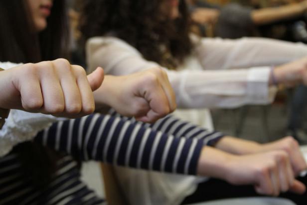 Mehrere Personen strecken ihre Fäuste nach vorne.