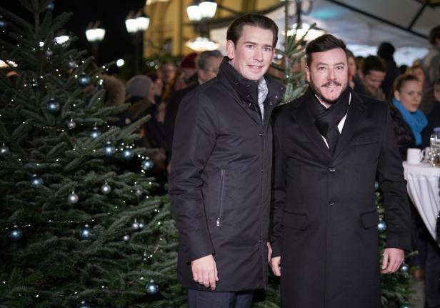 Sebastian Kurz und Rene Benko posieren nebeneinander stehend auf einem Weihnachtsmarkt