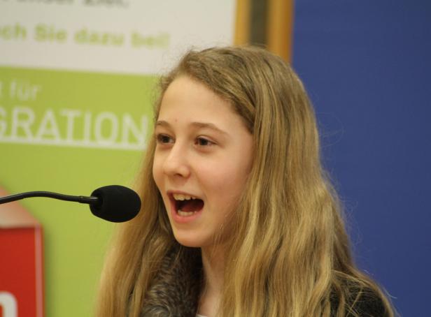 Ein junges Mädchen spricht in ein Mikrofon.