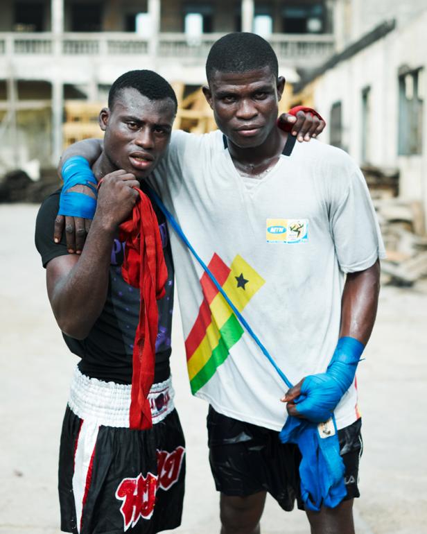 Zwei Boxer stehen mit bandagierten Händen und der ghanaischen Flagge auf ihren T-Shirts zusammen.