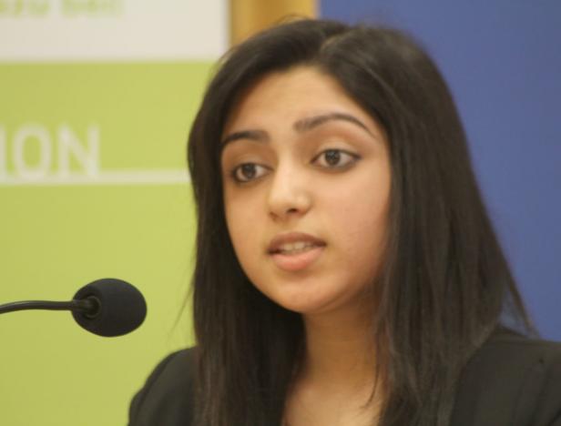 Eine junge Frau spricht vor einem Mikrofon.