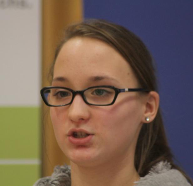 Eine junge Frau mit Brille spricht.