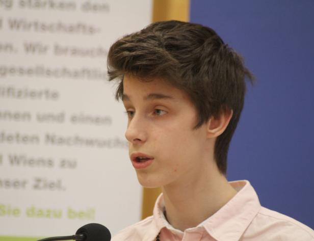 Ein junger Mann spricht vor einem Mikrofon.