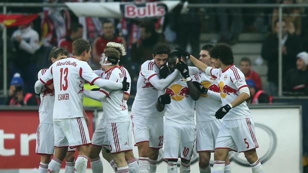 Eine Gruppe Fußballspieler von Red Bull umarmt sich auf dem Spielfeld.