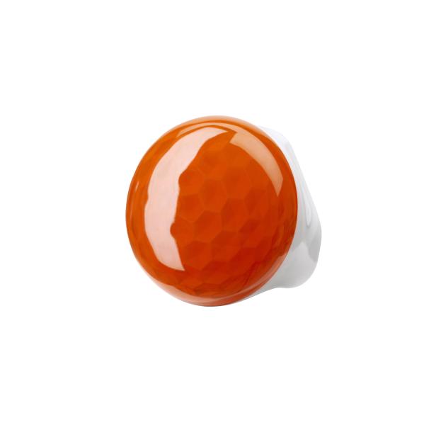 Ein orangefarbener Golfball liegt auf einem weißen Abschlag.