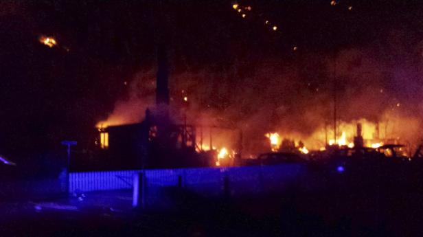 Ein Haus steht in Flammen, Rauch steigt in den dunklen Nachthimmel.