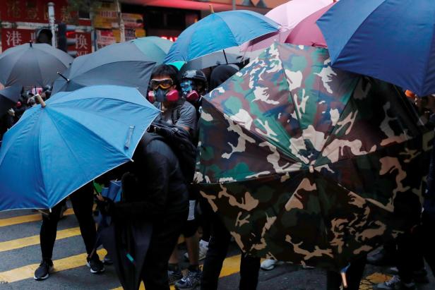 Anti-government protesters hold umbrellas as they march during a demonstration on the New Years Day to call for better governance and democratic reforms in Hong Kong