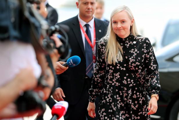 Eine blonde Frau wird von Reportern interviewt.