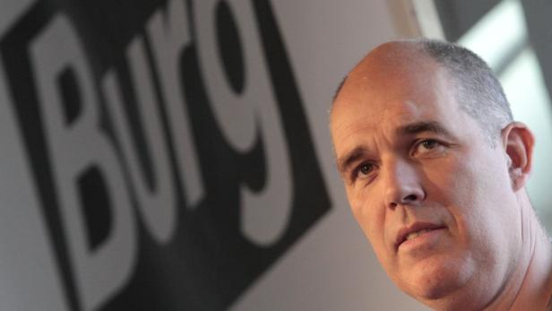 Ein Mann steht vor einem Schild mit der Aufschrift „Burg“.