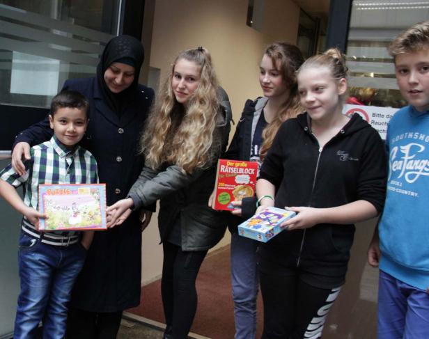 Eine Gruppe von Kindern und eine Frau halten Puzzles und einen Rätselblock in ihren Händen.